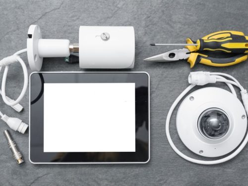 CCTV camera, pliers, screwdriver and blank screen digital tablet.